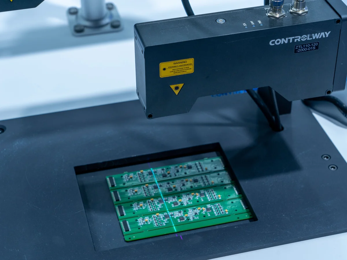 Endüstriyel işlem düzeneğinde yeşil elektronik kart paneli ve optik başlık